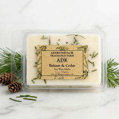 Adirondack Fragrance Farm soy wax melt in packaging with balsam and cedar fragrance on a marble surface.