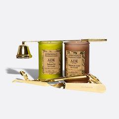 Two candles with labels and gold candle holders on a white background