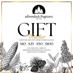 An Adirondack Fragrance gift card with black and white floral and pine cone designs, including a logo and text detailing the gift card amount and usage instructions.