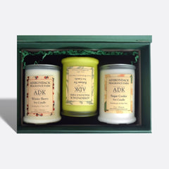 Three Adirondack Fragrance Farm candles in a decorative box on a white background