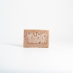 Bar of handmade birch soap with 'ADK' branding on a white background