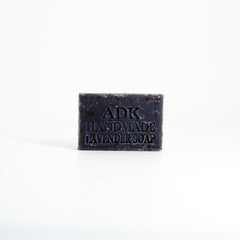 Bar of handmade lavender soap with 'ADK' branding on a white background