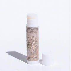 Lip balm with a white cap on a light gray background
