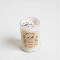 Scented candle with 'ADK' label on a white background