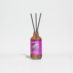 Diffuser bottle with purple label on a light gray background
