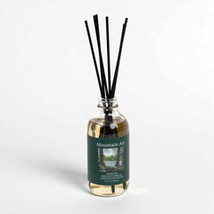 Diffuser bottle labeled 'Mountain Air' with black sticks on a white background