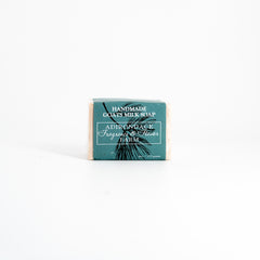 Bar of handmade goats milk soap with a green label on a white background
