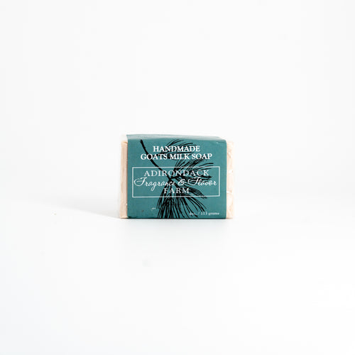 Bar of handmade goats milk soap with a green label on a white background